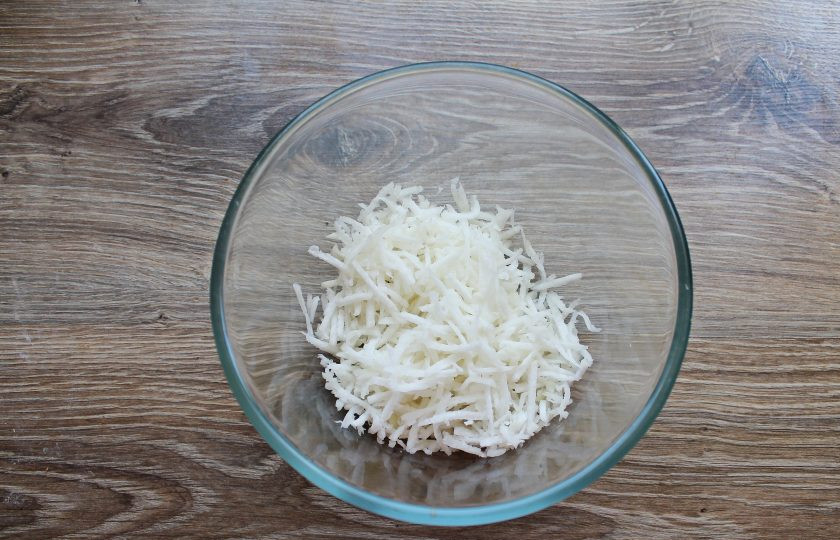 1. Этап. Салат с капустой и дайконом: Дайкон почистите от кожуры и порежьте тонкой соломкой, выложите в миску.
