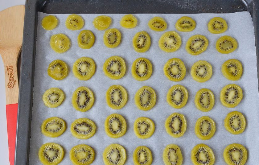1. Этап. Цукаты из киви: Противень застелите пергаментом, разложите ломтики киви. Сушите в духовке при 90 градусах 3-4 часа. Где-то через час я переворачиваю ломтики, чтобы они быстрее и равномернее сушились.