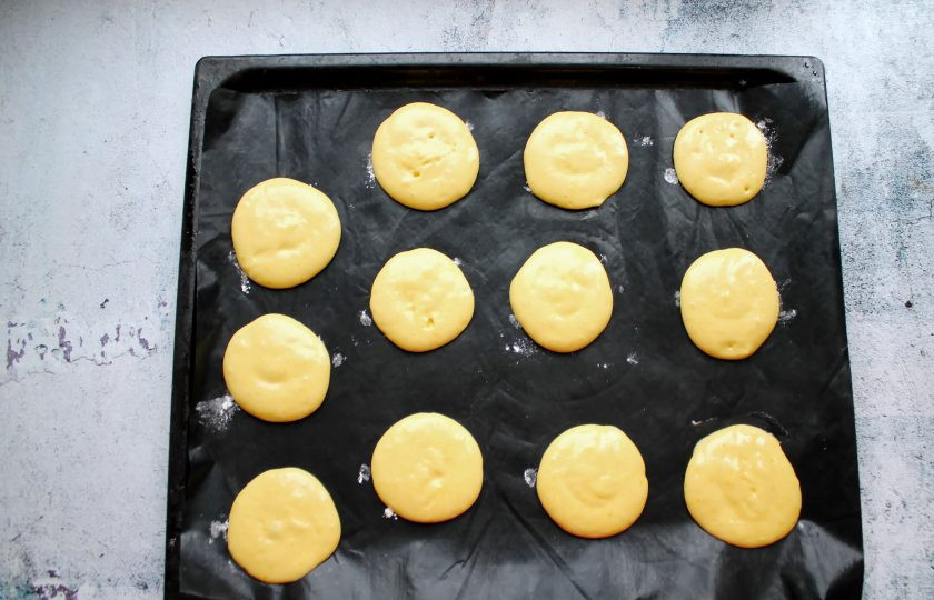 1. Этап. Бисквитное печенье Дед Мороз: Противень застелите пергаментом или ковриком и отсадите круглые лепешки на расстоянии друг от друга.