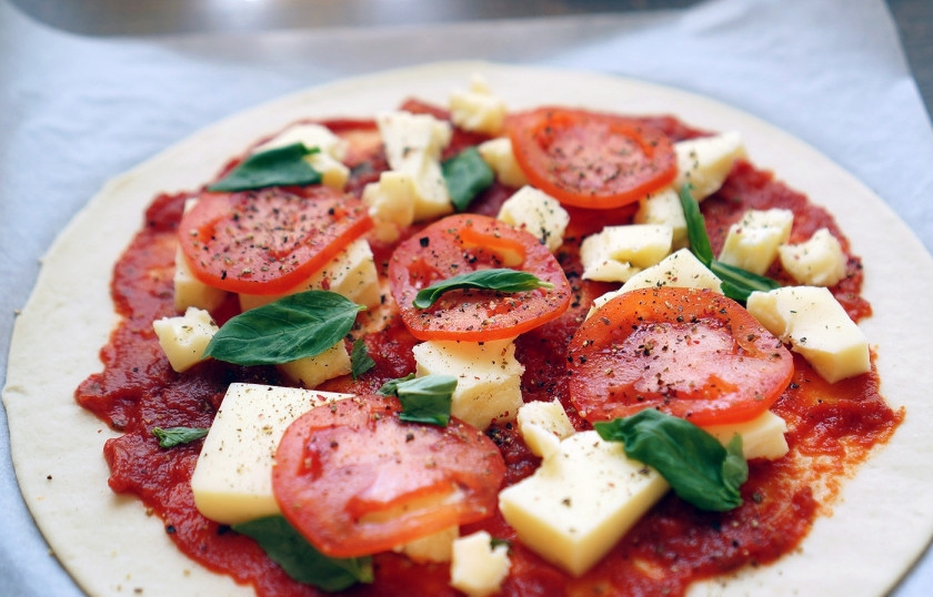 1. Этап. Пицца Маринара: Помидоры промойте и хорошо высушите. Затем нарежьте их тонкими кольцами. Выложите на пиццу помидоры, а также вымытые и просушенные листья базилика. Сверху немного посыпьте травами. Идеально использовать специальную приправу для пиццы.