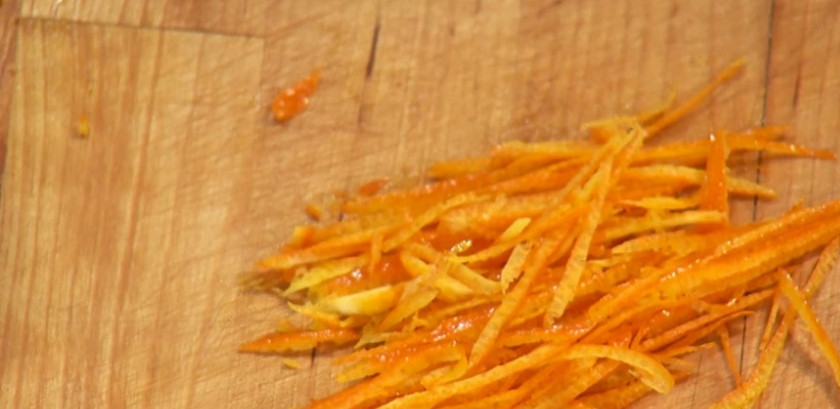 1. Этап. Кальмары с апельсинами: Мелко нарежьте цедру апельсина. Поместите в сотейник и залейте водой. Поставьте на огонь.