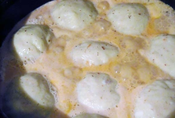 1. Этап. Картофельные шарики с начинкой: Влейте заливку в сковороду. Доведите блюдо до кипения на среднем огне, затем тушите его 5 минут под крышкой. В самом конце полейте картофельные шарики растопленным маслом.