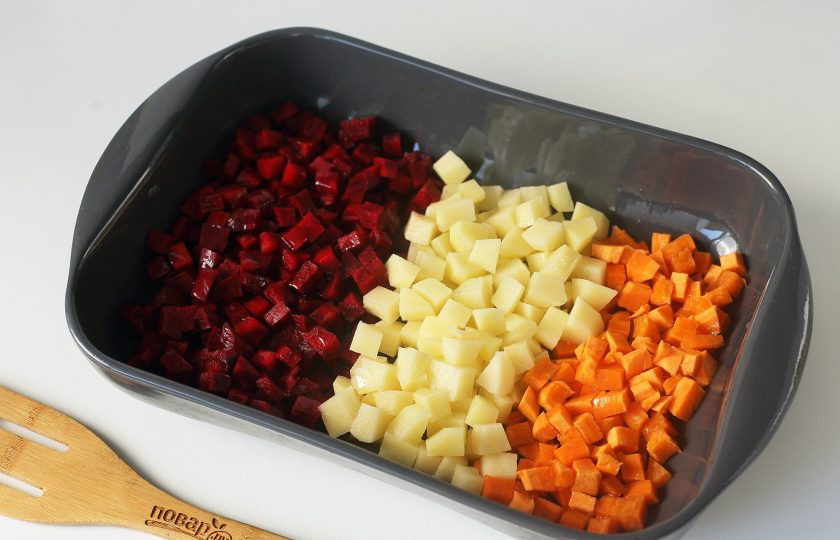 1. Этап. Винегрет из запеченных овощей: Свеклу, морковь и картофель очистите и нарежьте небольшими кубиками. Разложите кучками в форму для запекания, чуть посолите и сбрызните маслом. Накройте форму плотно фольгой и запекайте в духовке при температуре 180 градусов около 40 минут (до готовности всех овощей).
