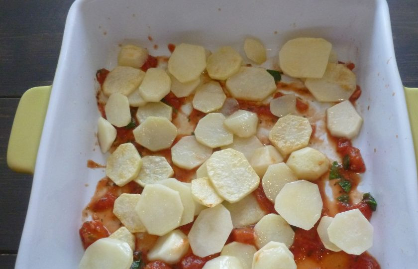 1. Этап. Тумбет: В квадратную форму для запекания налейте немного соуса. Выложите картофель. Приправьте солью и перцем.