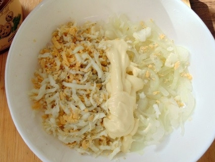 1. Этап. Салат Шапочка Деда Мороза: 3. Готовые яйца остудите и очистите. 3 яйца натрите на терке, соедините с луком. Заправьте майонезом, посолите и поперчите по желанию.