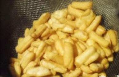 1. Этап. Чак-чак: 8. Выложить обжаренную лапшу на сито для того, чтобы дать стечь лишнему маслу. В другой сковороде растопить сахар с медом на слабом огне. Постоянно помешивать.