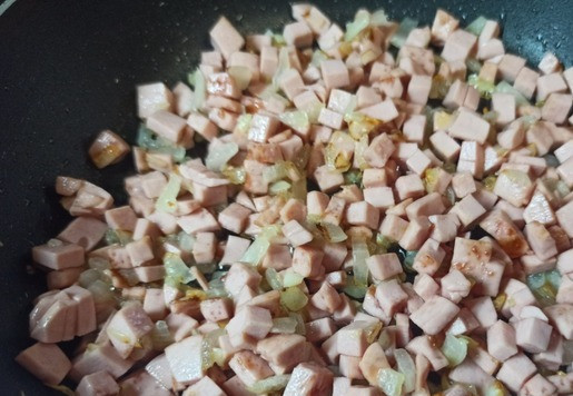 1. Этап. Сырный суп с колбасой и киноа: Варёную колбасу нарезать маленькими кубиками и добавить к луку. Обжарить всё вместе еще пару минут.