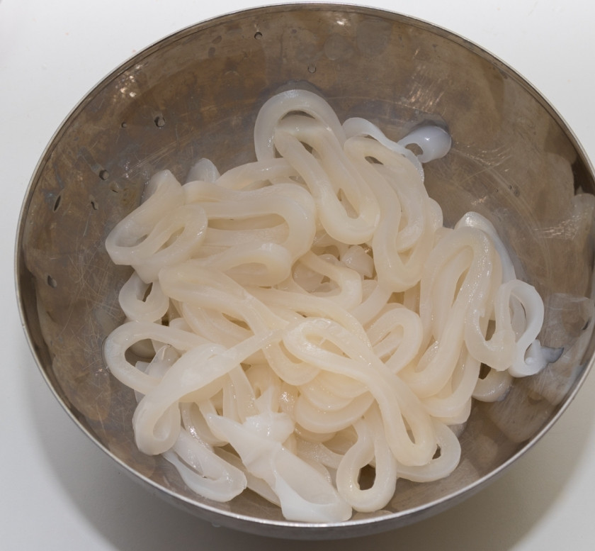 1. Этап. Жареные кальмары с овощами: Пока жарятся овощи, помоем и нарежем кальмары кольцами.