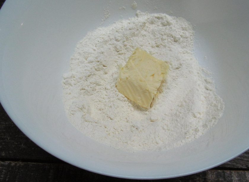 1. Этап. Капустное печенье: Муку смешайте с разрыхлителем, добавьте мягкое масло и перетрите руками в крупную крошку.