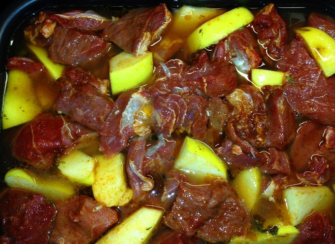 1. Этап. Козлятина, тушеная с рисом: Мясо козы очистите от пленок и жира, порежьте на куски. Айву почистите, порежьте и смешайте с мясом. Посолите и добавьте столовую ложку паприки. В посуду для запекания выложите рис с зеленью, а сверху мясо с айвой. Добавьте воды и оросите соком лимона.