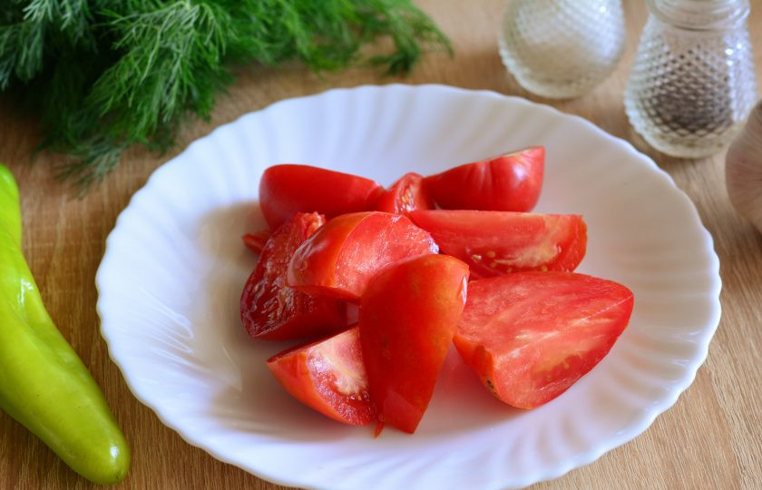 1. Этап. Горлодер на зиму без хрена: Промойте помидоры и нарежьте дольками, срезая плодоножки.