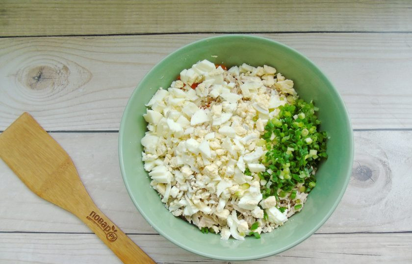 1. Этап. Салат Оливье с курицей, сладким перцем и оливками: Яйца сварите вкрутую, охладите и очистите. Мелко нарежьте яйца и зеленый лук.