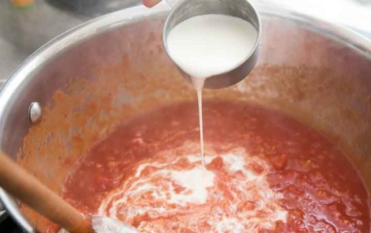 1. Этап. Креветки с макаронами: Очень мелко порежьте томаты, отправьте их в сотейник вместе с водкой, сливками, цедрой лимона.