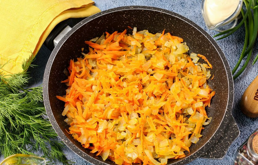 1. Этап. Кальмары фаршированные грибами на сковороде: Морковь натрите на тёрке, лук нарежьте мелкими кубиками. Обжарьте овощи на растительном или сливочном масле до мягкости.