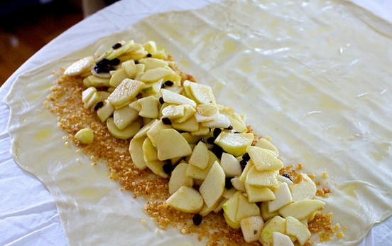 1. Этап. Штрудель с яблоком: 8. Выложите панировочные сухари, а сверху распределите яблоки с изюмом.