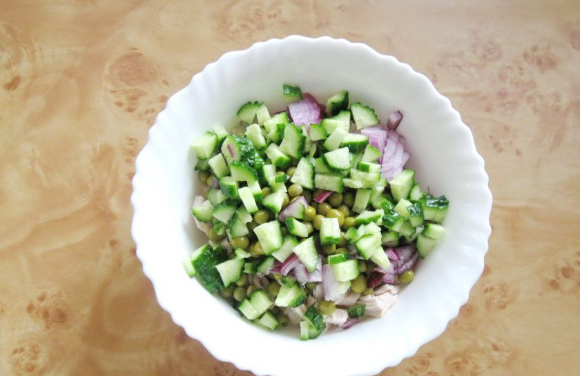 1. Этап. Салат из курицы с рисом: Крупный свежий огурец нарежьте и добавьте в салатник.
