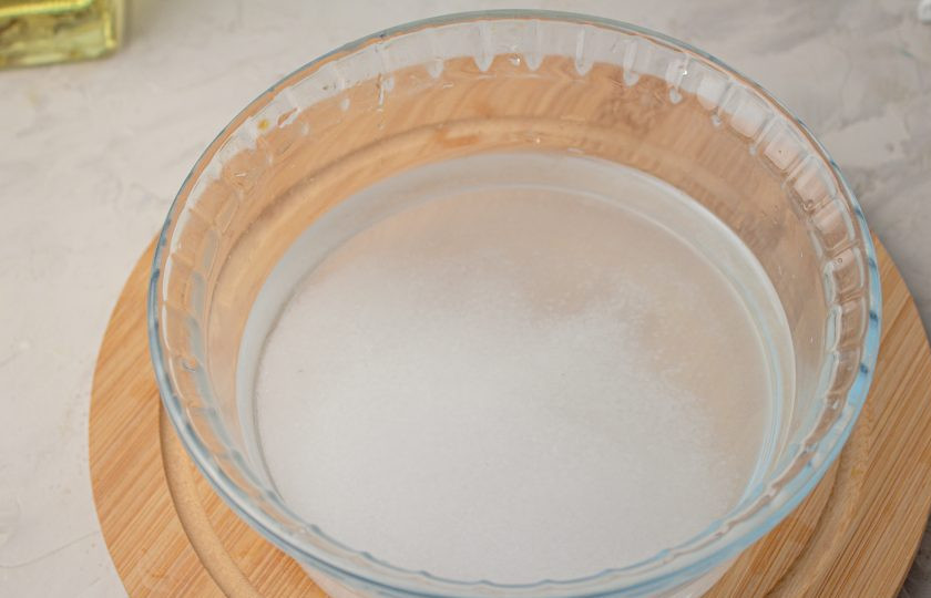 1. Этап. Малосольный лосось за 15 минут: В подходящую посуду налейте кипяченую воду комнатной температуры, добавьте соль и сахар. Тщательно перемешайте, чтобы они растворились.