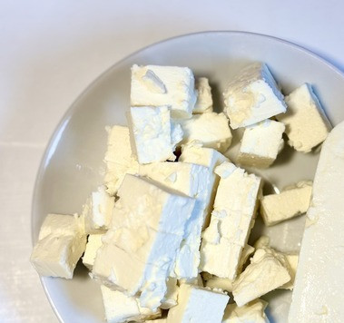 1. Этап. Паста с овощами и фетой из духовки: От феты отрезать кусочек граммов 30, отложить для подачи, остальное порезать кубиками.