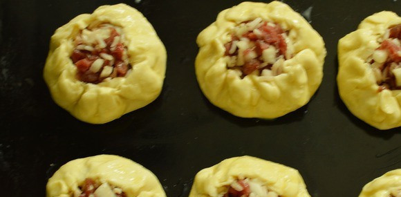 1. Этап. Вак бэлеш с рисом: Кладем пироги на противень, смазываем их яичным желтком.