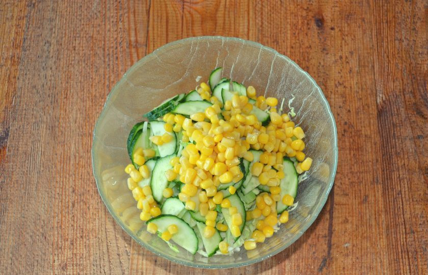 1. Этап. Салат с капустой, огурцами и кукурузой: Добавьте консервированную кукурузу. Если под рукой есть свежая кукуруза, можно использовать ее.