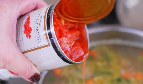 1. Этап. Перловый суп с солеными огурцами: 7. Откройте банку консервированных томатов и выложите ее содержимое в кастрюлю.