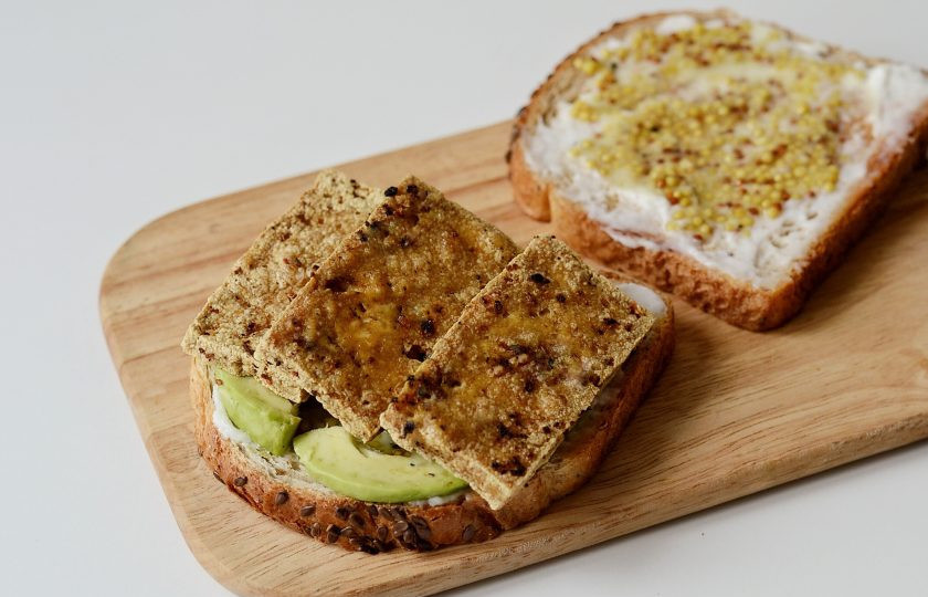 1. Этап. Бутерброды с тофу: Смажьте хлеб майонезом и горчицей. Выложите ломтики авокадо. Добавьте по 2-3 ломтика тофу на каждый бутерброд.