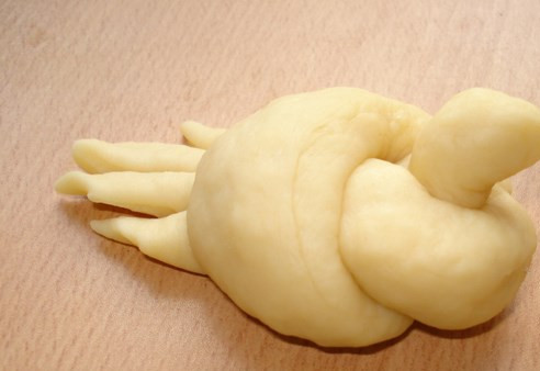 1. Этап. Булочки в форме птичек: Из каждого жгутика слепите жаворонка. Для этого просто просто завяжите узелок, из одного конца сделайте голову, а другой 