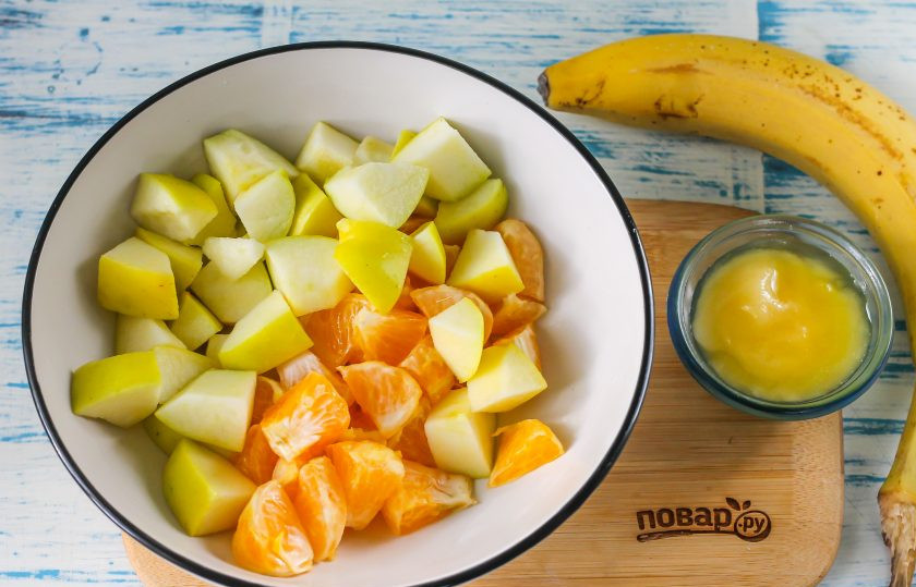 1. Этап. Фруктовый салат с йогуртом для детей: Промойте яблоко, мандарин и грушу. Натрите цедру с цитрусового на терке с мелкими ячейками для присыпки блюда, стараясь не задеть белый слой. Очистите плод от кожуры и белого слоя. Яблоко разрежьте на четыре части, срежьте семенные блоки и промойте, нарежьте средними кубиками. Плод мандарина разделите на дольки, нарежьте их на части и добавьте к яблоку.