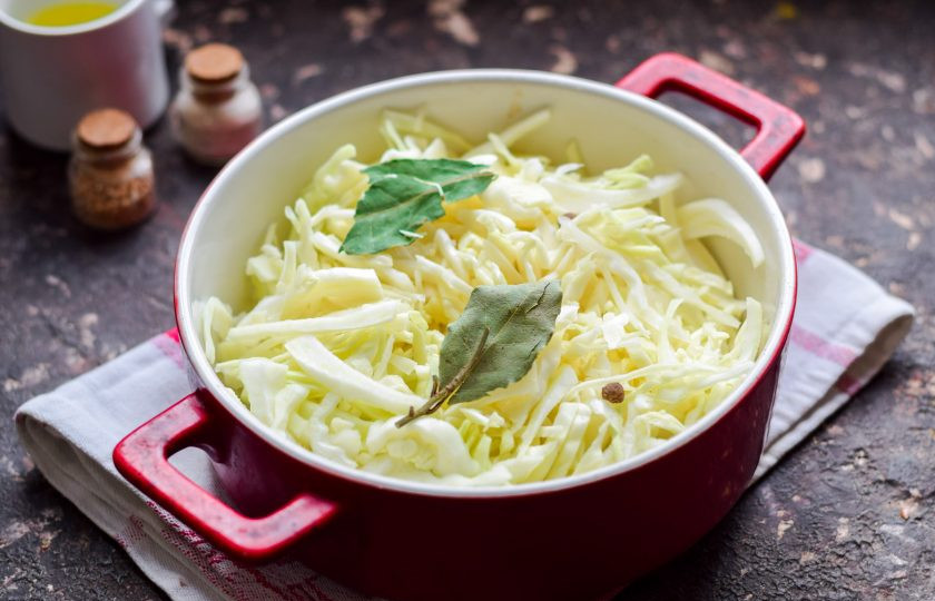 1. Этап. Тушеная капуста в духовке: Переложите капусту в форму, добавьте масло, лавровый лист и перец горошком. Духовку прогрейте до 200 градусов.