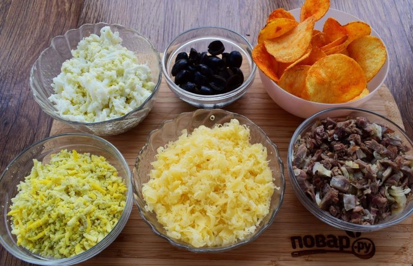 1. Этап. Салат Подсолнух: 2. 3 желтка натрите на мелкой терке. 3 белка и 1 яйцо натрите на мелкой терке в отдельную емкость. Маслины разрежьте вдоль на две половинки. Грибы нарежьте тонкими ломтиками, лук измельчите и обжарьте в течение 1 минуты на разогретом растительном масле, посолите по вкусу.