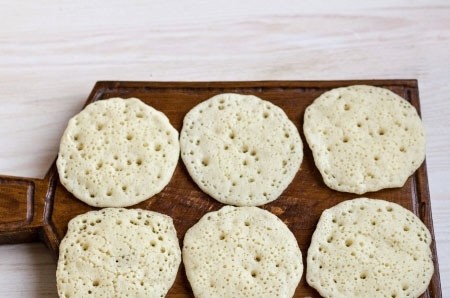 Марокканские блинчики 1. Этап. Марокканские блинчики: Сковороду на которой будете готовить блинчики смажьте с помощью кисточки растительным маслом, налейте тесто столовой ложкой, такие блинчики должны быть размером как оладья. Обжарьте в течении нескольких минут не переворачивая. Эти блинчики не переворачиваются во время приготовления. Блинчики выложите отдельно друг от друга на деревянную доску или любую поверхность застеленную пергаментом, просто когда они горячие они липнуть друг к другу, когда блины немного остынуть их можно будет сложить без проблем стопкой.