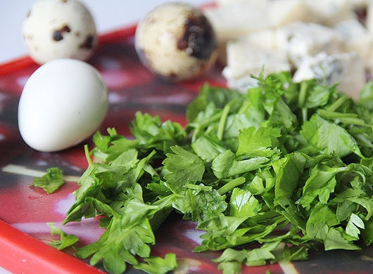 1. Этап. Щавелевый крем-суп: В кастрюлю налейте воду, выложите в нее перепелиные яйца, варите их три минуты. Затем остудите яйца под холодной водой и очистите их от скорлупы. Петрушку вымойте и нарубите. Нарежьте сыр на небольшие кубики.