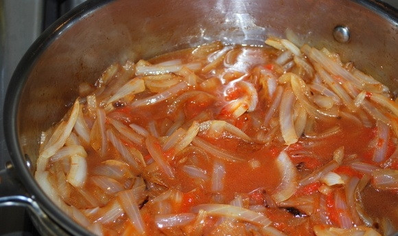 1. Этап. Солянка с оливками: 4. Нарежьте маринованные огурчики и добавьте к луку. Обжарьте 2-3 минуты. Выложите томатную пасту, добавьте стакан огуречного рассола. Поперчите немного по вкусу и оставьте минут на 5.