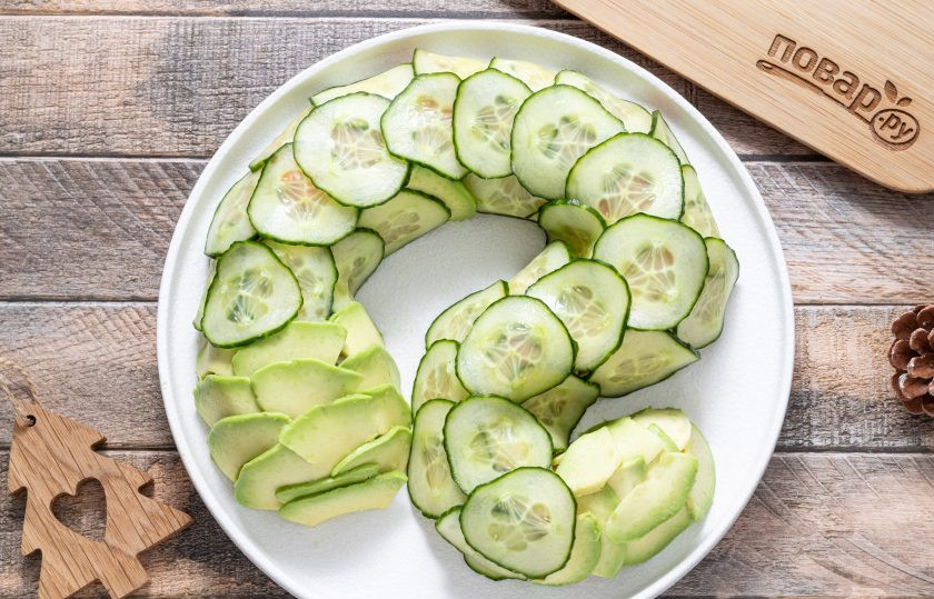 1. Этап. Вегетарианский салат Змея: Покройте ломтиками авокадо и кружочками огурца салат. Я сделала голову и кончик хвостика из авокадо, а туловище из огурца.