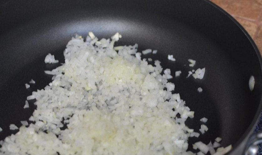 1. Этап. Тосканский суп: Мелко нарезанный лук и чеснок, пропущенный через пресс обжариваем в масле на сковородке до мягкости и добавляем в кастрюлю в кипящую воду.