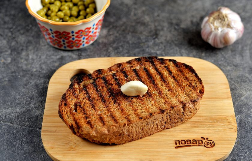 1. Этап. Брутальные бутерброды Три огурца: Остывшие ломтики хлеба щедро натрите крупным зубчиком чеснока.