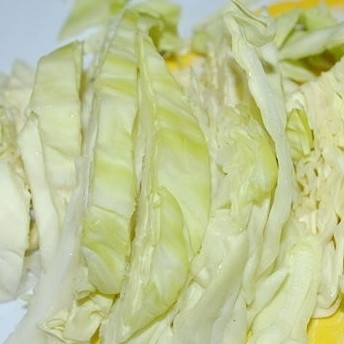 1. Этап. Тушеная капуста с беконом: 3. Нарежьте каждую четвертинку капусты полосками.