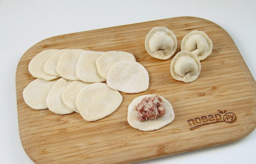 1. Этап. Московские пельмени: Затем раскатайте кусочки теста в кружочки, края которого должны быть немного тоньше середины. На кружочек по центру положите фарш и формуйте пельмени в виде полумесяца или ушка.