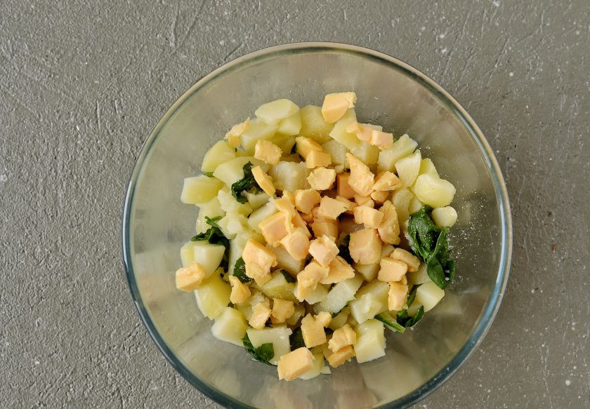 1. Этап. Слойки с картошкой: Веганский сыр нарежьте кубиками. Соедините в миске сыр, картошку и шпинат. Добавьте сухой чеснок, посолите по вкусу и перемешайте.