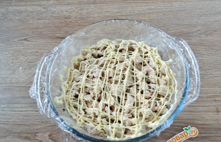 1. Этап. Салат Грибная поляна: Куриную грудку нарежьте мелкими кусочками и выложите следующим слоем. Сверху покройте сеточкой майонеза.