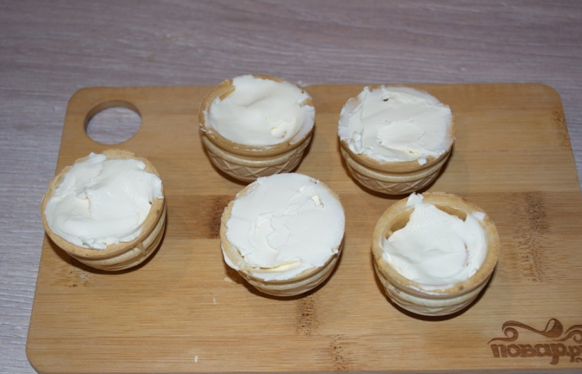 1. Этап. Тарталетки с икрой и сливочным сыром: Наполните тарталетки крем-сыром. При отсуствии крем-сыра можно взять сметану, предварительно выложив ее на марлю. Сметана спустит сыворотку и станет близкой к крем-сыру. Крем-сыр можно приготовить и самостоятельно.