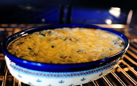 1. Этап. Сырный соус с артишоками и шпинатом: 8. Посыпать дополнительным тертым сыром и выпекать при температуре 190 градусов в течение 15 минут, пока сыр не расплавится и не начнет бурлить. Подавать с ломтиками питы, чипсами тортильяс и крекерами.