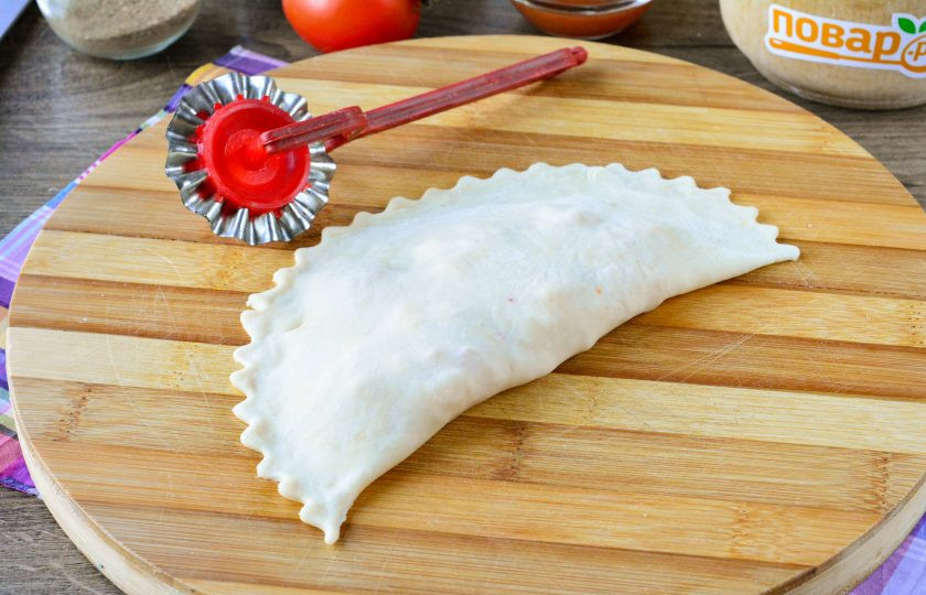 1. Этап. Пицца в чебуреке: Свободным краем теста закройте начинку, защипните тщательно все края. Также по краю можете пройтись специальным фигурным колесом.