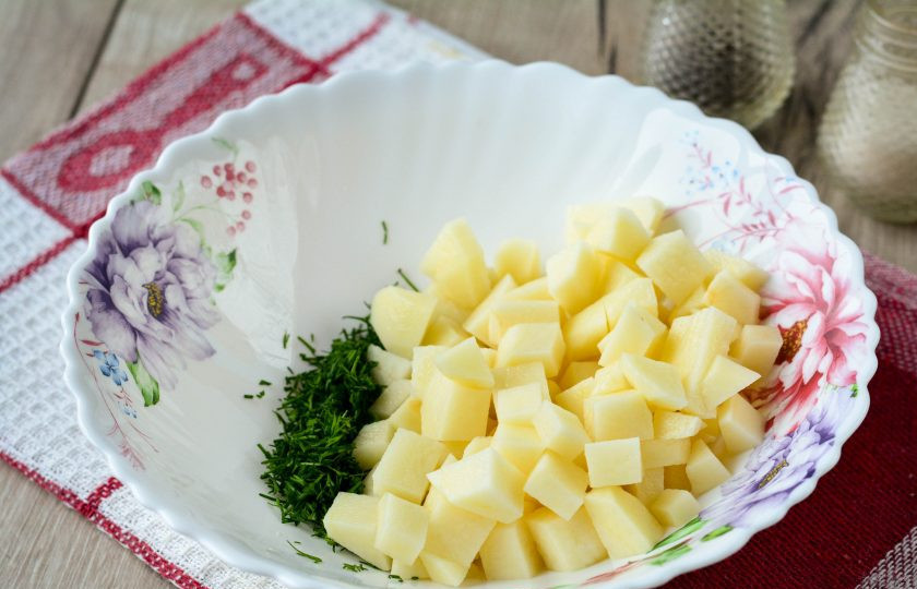 1. Этап. Татарские пирожки с картошкой: Для начинки нарежьте небольшими кубиками почищенный картофель, добавьте к нему мелко рубленый укроп.