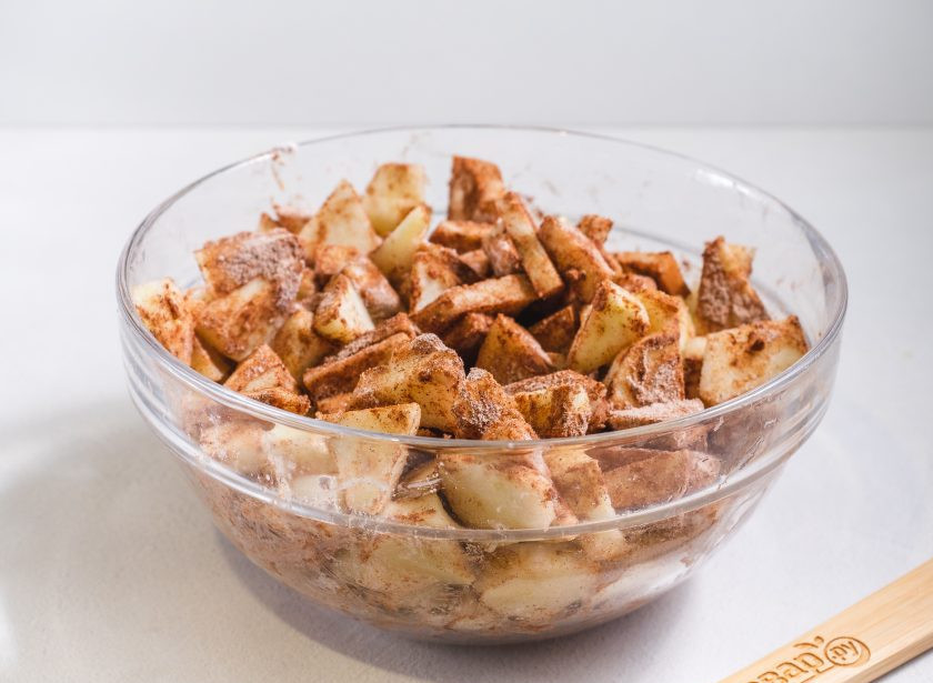 1. Этап. Шарлотка с яблоками с хрустящей корочкой: Крахмал смешайте с корицей и обваляйте в этой смеси нарезанные яблоки. Сбрызните лимонным соком и перемешайте.