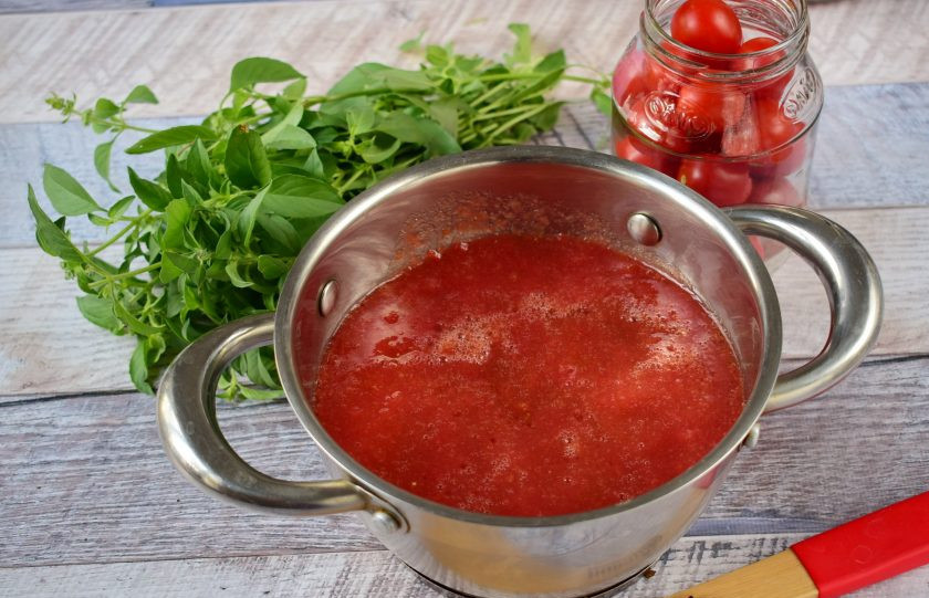 1. Этап. Помидоры-черри в собственном соку с базиликом: Крупные помидоры перекрутите через мясорубку со специальной насадкой для томатного сока. Либо обдайте кипятком, снимите кожицу, пюрируйте блендером. Томатный сок, соль и сахар доведите до кипения, на медленном огне варите в течение 10 минут. При появлении снимите пенку.