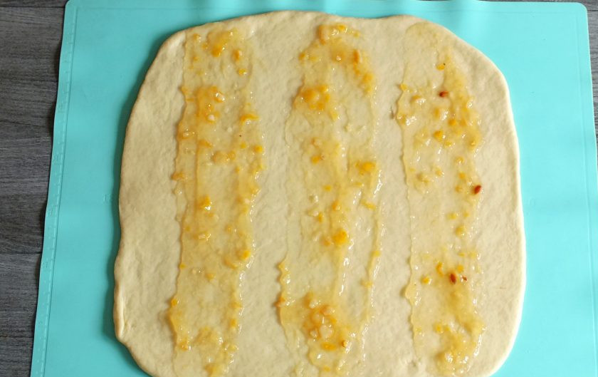 1. Этап. Дрожжевой пирог с яблоками и изюмом: Отступив от края пласта нанесите полосу лимонного варенья. Отступив еще дважды, сделайте еще две полосы.