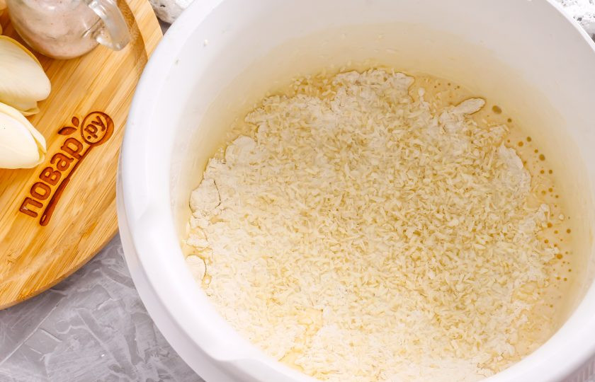 1. Этап. Кокосовый бисквит в мультиварке: Вслед за мукой добавьте в емкость кокосовую стружку. Ванильный сахар и разрыхлитель добавлять не нужно! Аккуратно вмешайте сыпучие составляющие с помощью силиконовой лопатки.