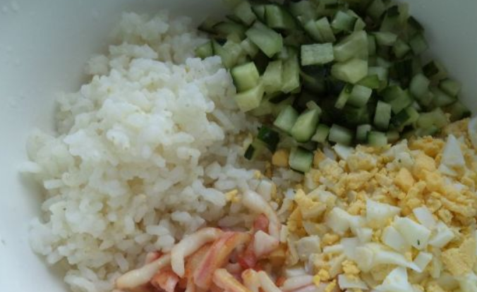 1. Этап. Салат из кальмаров с рисом: В миску выкладываем: порезанные огурцы, яйца, кальмаров и рис. Солим по вкусу.