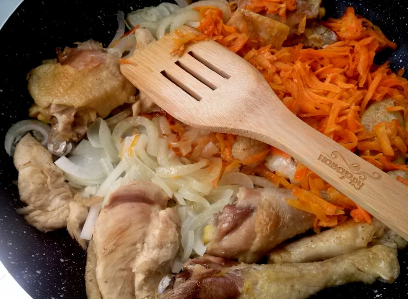 1. Этап. Чахохбили из курицы по-грузински: Добавьте к мясу лук, жарьте 5 минут, затем добавьте морковь и перец.